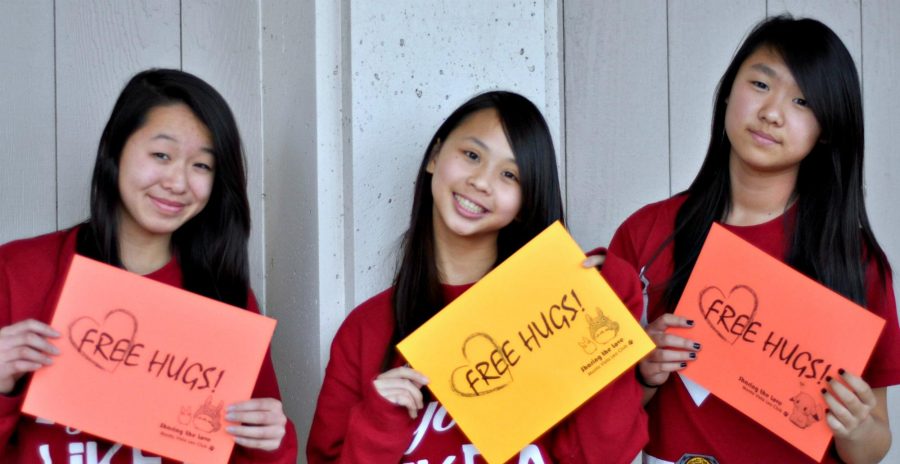 President senior Tiffany Wu, Director of Events sophomore Jessica Ho, and Director of Projects sophomore Alice Ma (from left to right) show off their “Free Hugs” signs that will be used on Friday. “I think it’s just to tell people to appreciate the people around us,” Wu said. “Even in our own community here, there is a lot we can do to help. And a small token of appreciation can go a long way.” Photo by Karishma Mehrotra.