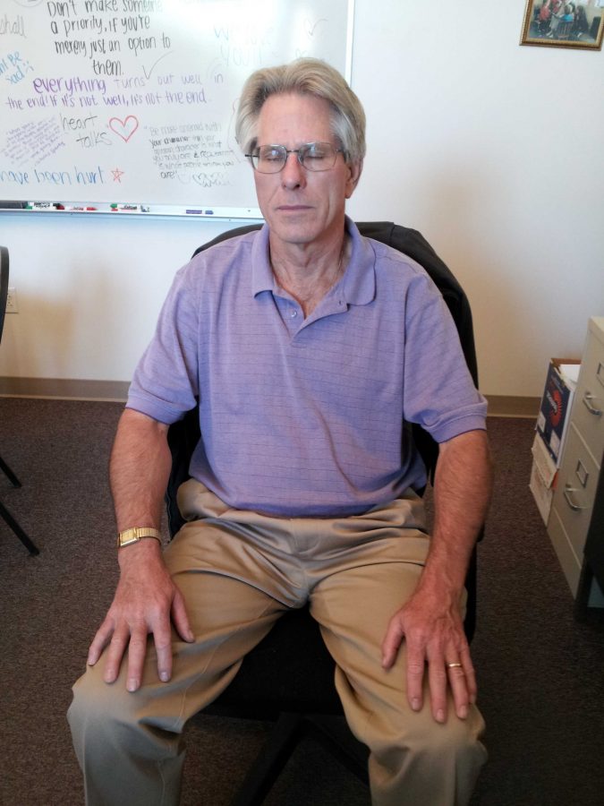 Only the asynchronous tick of clocks can be heard as Student Advocate Richard Prinz meditates in his chair on Sept. 28. Photo by Bryan Wang.