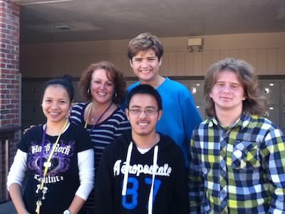 Special education students, seniors Justin Quigley and William Tan and junior Daniel Fairbairn, stand with job coaches Syvees Sazon and Tina Volzing. Under the coaches guidance, these students spend brunch and lunch serving food and helping out in the cafeteria, and they look forward to the anticipated change. Photo by Carissa Chan.