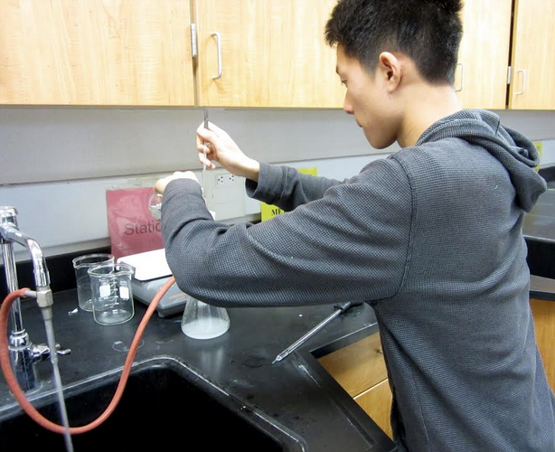 Junior David Wang synthesizes acetylsalicylic acid (aspirin) through the Fischer esterification of salicylic acid and acetic anhydride. Labs like this were conducted by Wang in preparation for the Chemistry Olympiad. Photo by Jenny Xu.  
