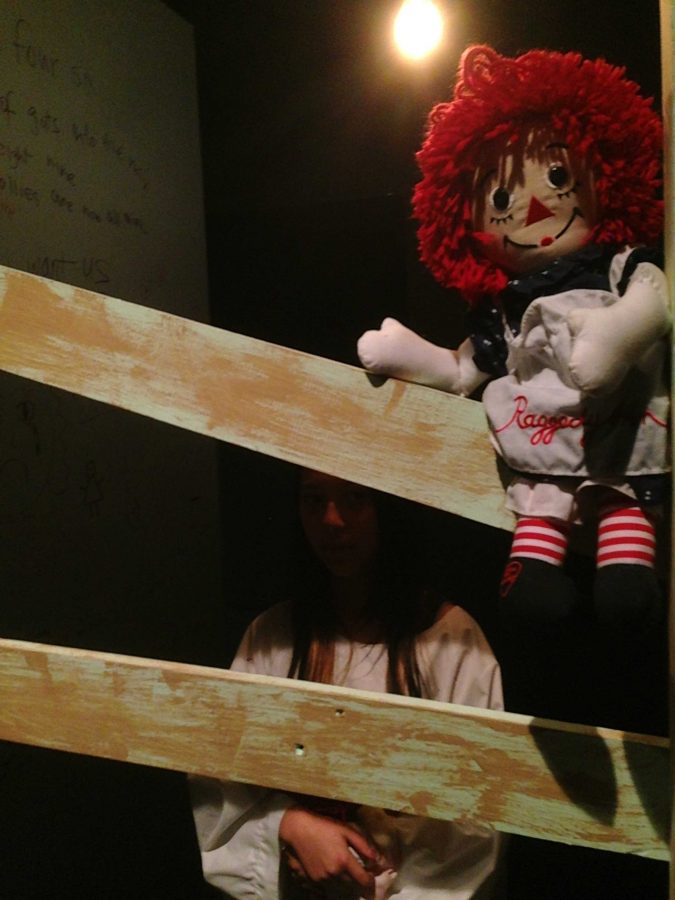 An asylum patient stands in her boarded-up stall, next to a wall covered in “bloody” writing. The Drama students practiced to immerse themselves in their insane characters’ roles. Photo by Rhonda Mak.
