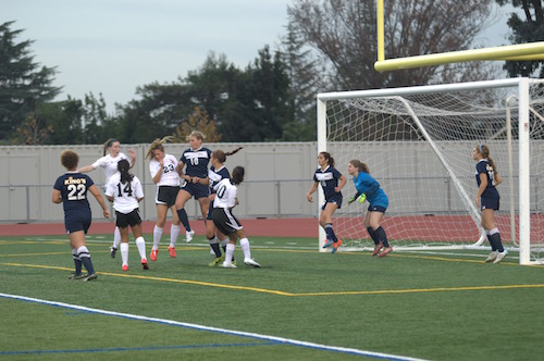 Freshman Nina Biondi collides with a player from Kings Academy as she reaches for the ball following a corner kick. The Knights had several chances to score a goal following corner kicks, but missed each time, with the ball hitting the edge of the goal post instead. Photo by Varsha Venkat.