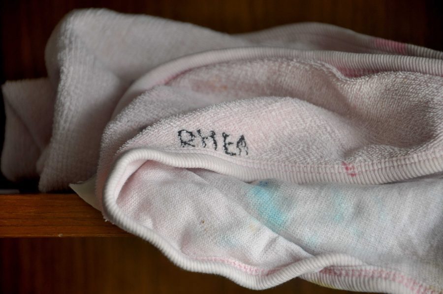 Senior Rhea Solmon’s old towel is now faded and splotched with old color. The black thread that her mother, Sujatha Solomon, used to sew Rhea’s name onto the towel is coming off. Photo by Mingjie Zhong. 