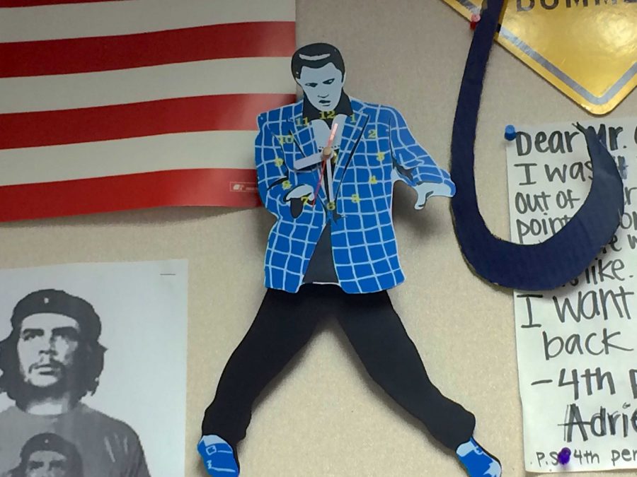 A broken Elvis clock is one of the many objects on Clarke’s classroom walls. Photo by Amita Mahajan. 