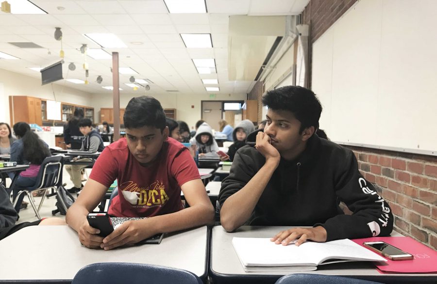 Junior Ronak Hungund (right) watches Junior Nikhil Prakash (left) play a game of ‘Ballz’ on their last day of AP Biology. They voluntarily sat next to each other the entire year. 
