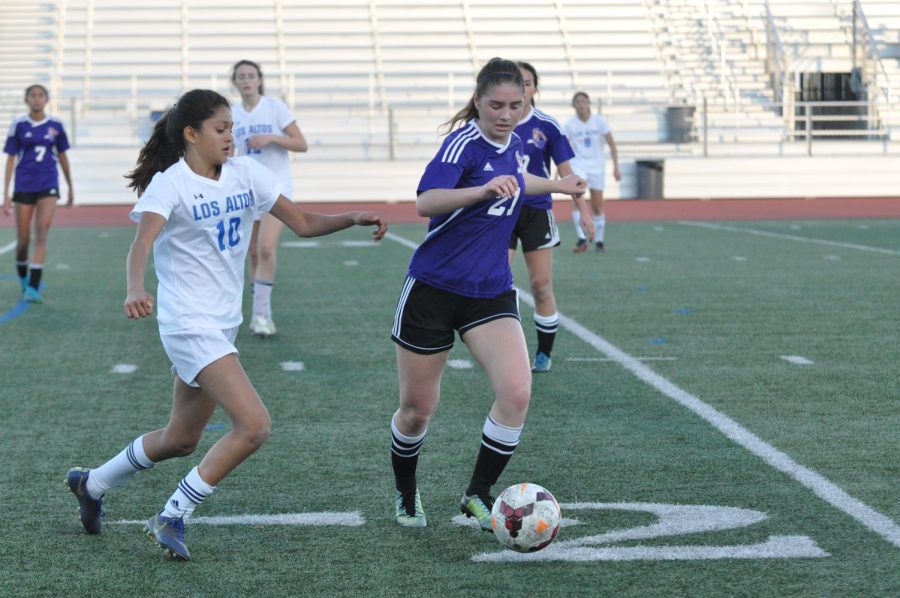Junior Erica Haskell steals the ball from a Los Altos HS defender, while trying to keep the ball to pass to a teammate. Photo by Justine Ha. 