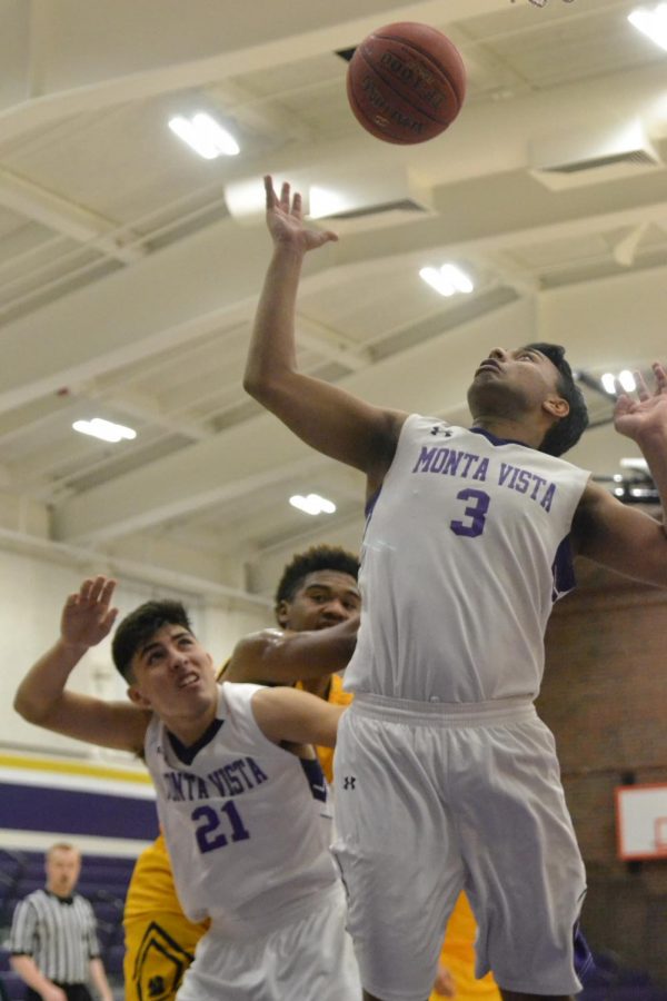 Junior Arvind Jagdish reaches up for a rebound as senior Josiah Figueroa covers him. Photo by Brandon Ng.