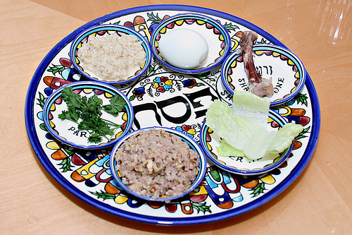 The typical seder plate consists of beitzah (a hard-boiled egg), zeroa (a shankbone), maror (bitter herbs), charoset (sweet paste), and karpas (green vegetables) as shown clockwise in this picture. Photo | Creative Commons