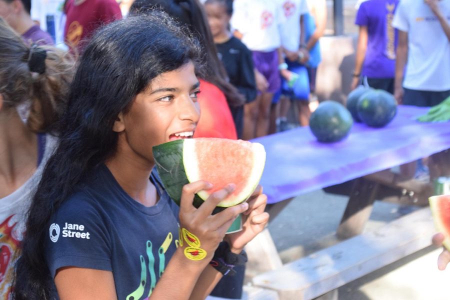 Freshman Avani Kalari smiles while eating a large piece of watermelon.