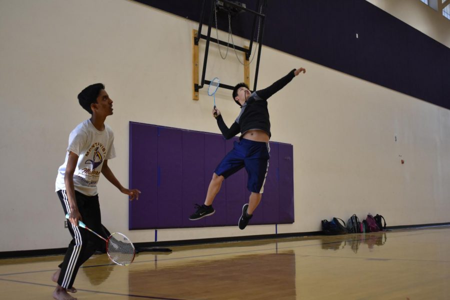 Junior Alvin Tian performs a jump smash during a doubles match of badminton.