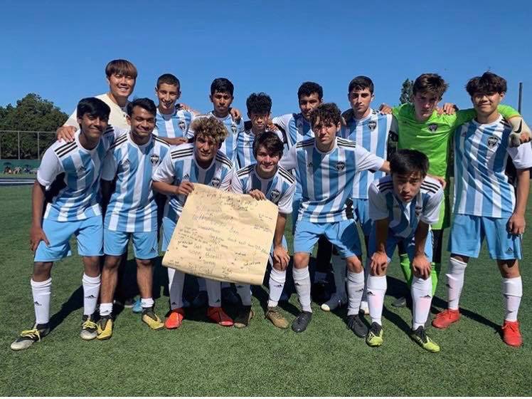 Wei (top right) poses with his club team holding a get well soon poster after one of his teammates broke his wrist during a game.// Used with permission from Rick Wei.