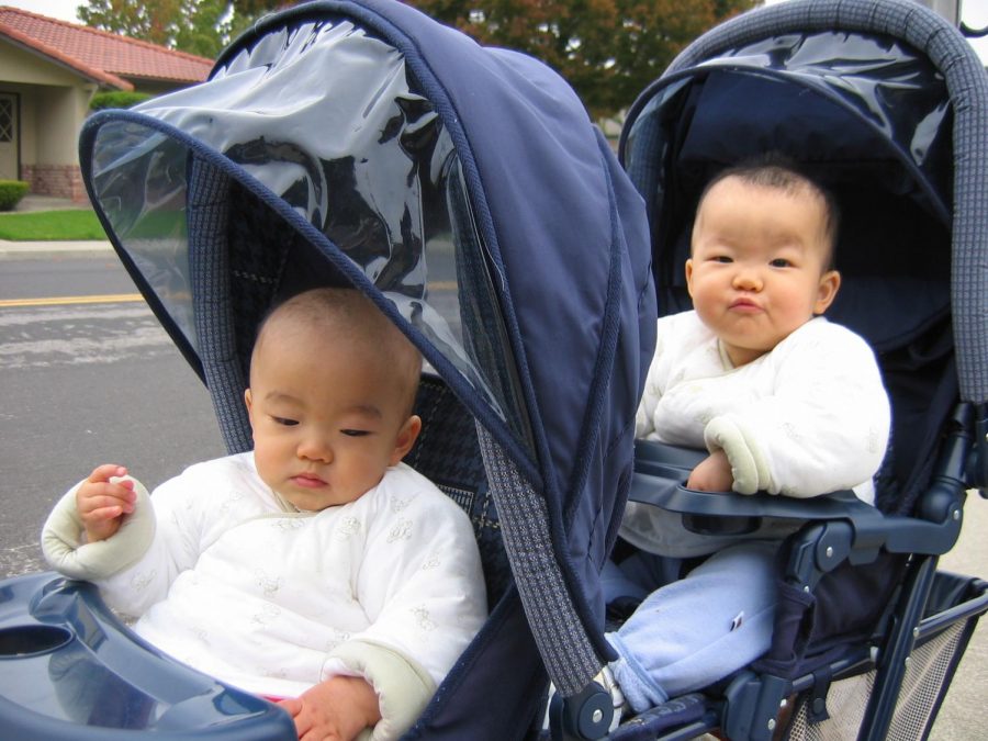 My sister and I, age 2, sit in a double stroller. We were often dressed in similar clothing when younger.