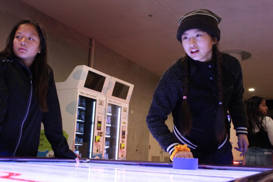 Freshman Amy Wu plays air hockey in the arcade center. 