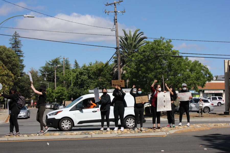 Some protestors stand in the middle of South De Anze Blvd. as cars passing by honk to show support.