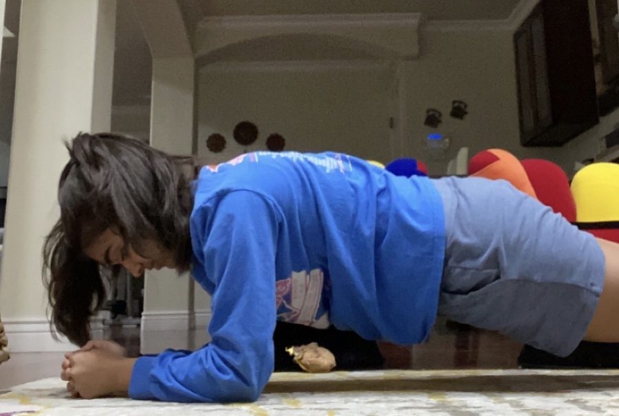 Junior Arushi Tyagi holds a plank position during her daily workout in her house. 