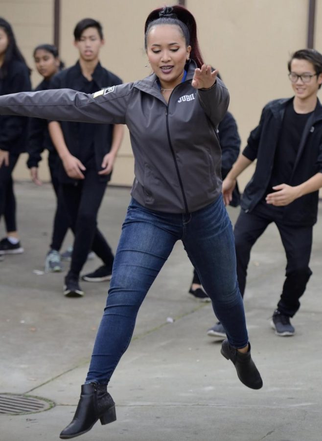 Assistant Color Guard Director Jubilee Hardwick demonstrates a move to her students during practice. 