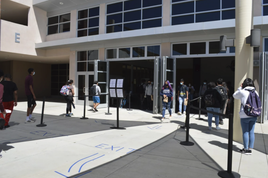 Students at MVHS pick up their lunch while maintaining social distancing protocols. Tape has been placed at six feet intervals to keep students safe.