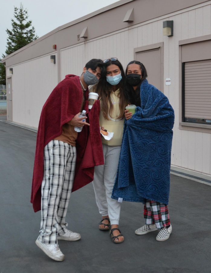 Seniors Ronit Avalani, Diya Sarin and Yana Padte pose for a photo after the sun rose — due to smoky skies from the California wildfires, the sunrise was subtle. 

