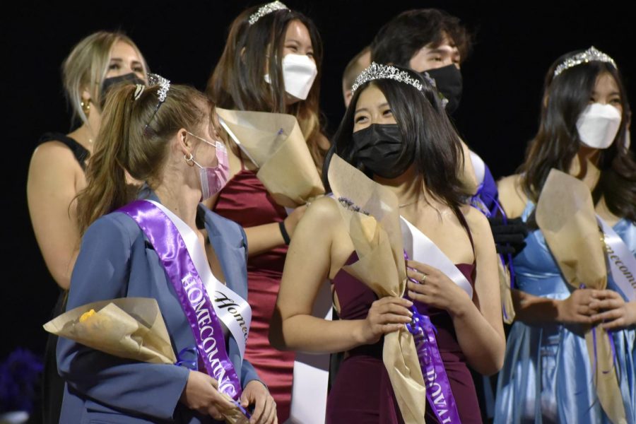 Seniors Sophia Bokovikova and Cindy Zou celebrate after being crowned as the two members of Homecoming Royalty. Following the announcement, Homecoming court members exit the field and take photos on the side of the bleachers. 