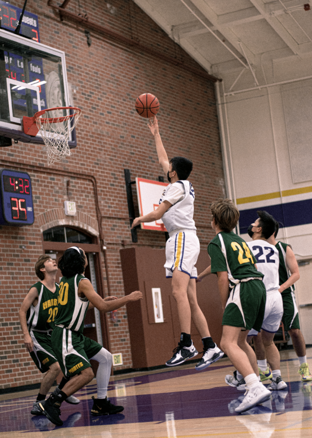 Junior Jesse Li towers over the other players as he attempts to score. 