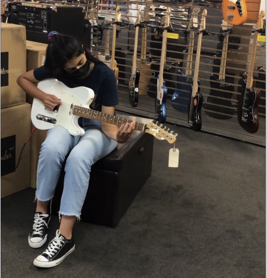 My parents sneaked a picture as I test out guitars in the music store over the summer.