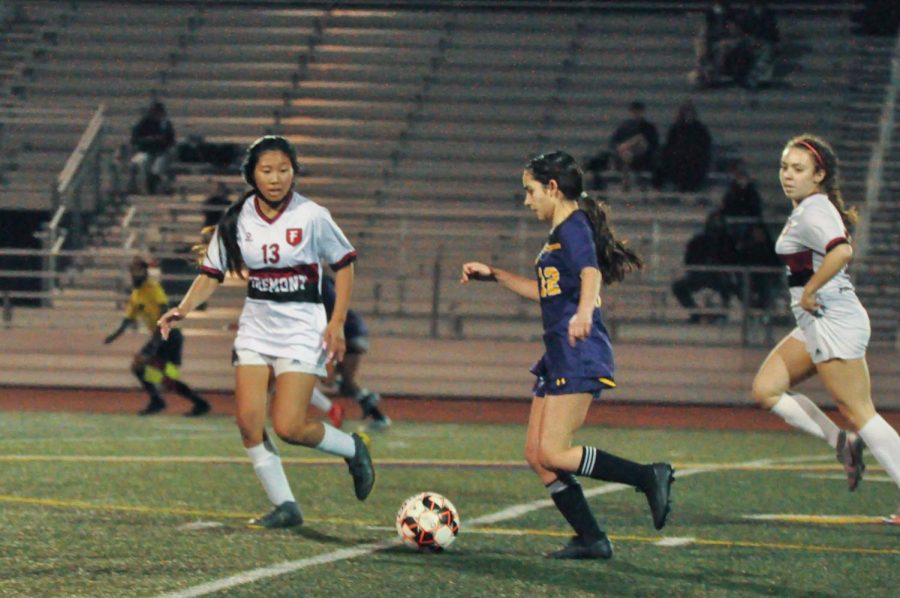 Sophomore Niku Sedarat drives the ball through midfield as teammates run forward hoping to receive a through ball.