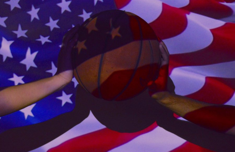 Two people hold a basketball with a projected American flag.