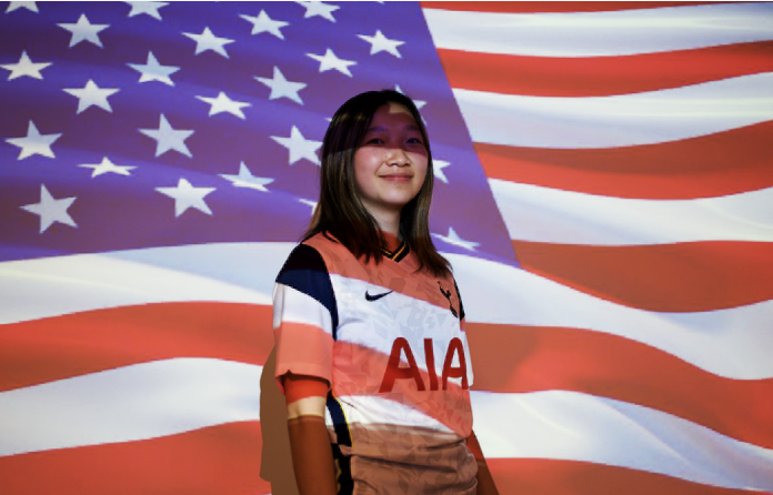Junior Maggie Du poses in front of the Unites States flag wearing a soccer jersey expressing her patriotism.