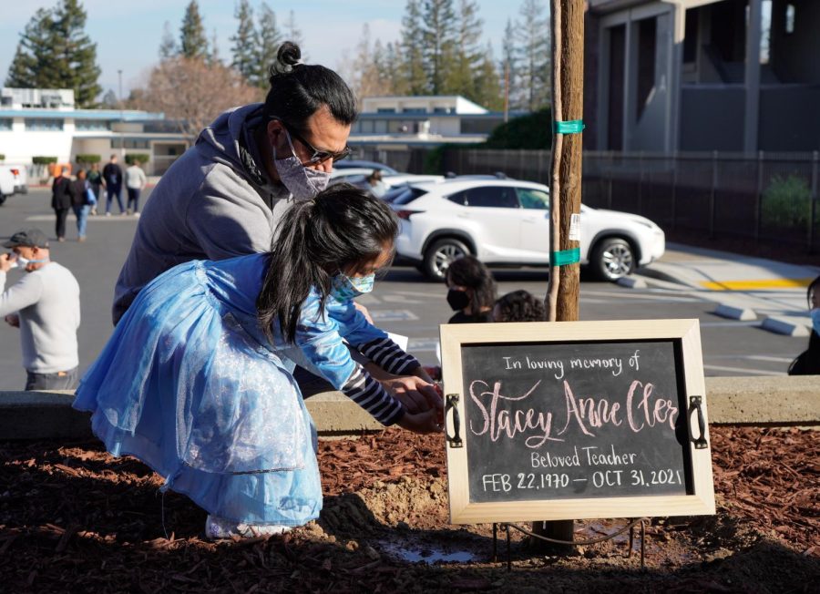 Athletic trainer Javier Margarito and his daughter pour a cup of water on Cler’s tree before  in the nearby Olive Court to enjoy some of Cler’s favorite foods. Photo by Gauri Manoj