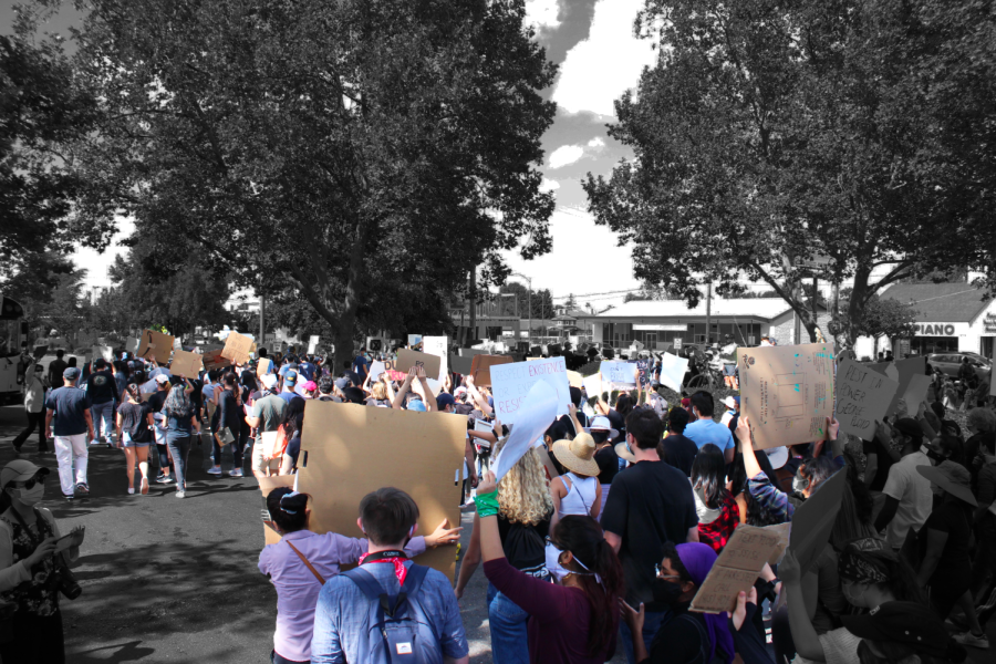 A large crowd of protestors march forward during a rally.
