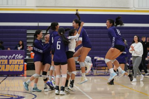 The team celebrates after winning the final point in the fourth set, defeating HHS 3-1.