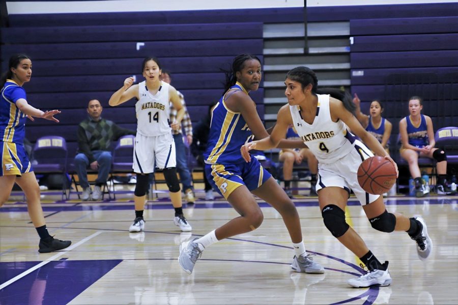 Senior Varshini Peddinti shields the ball from a PHS defender as she dribbles down the court. 
