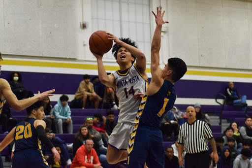 Junior Matthew Lau pushes through an MHS defender for a layup 