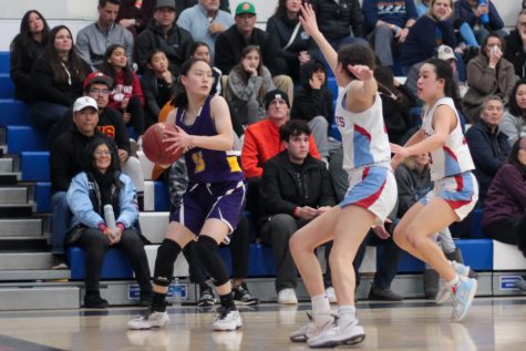 Junior Carolyn Ruan looks for an open team member to pass to while two HHS players guard her. 