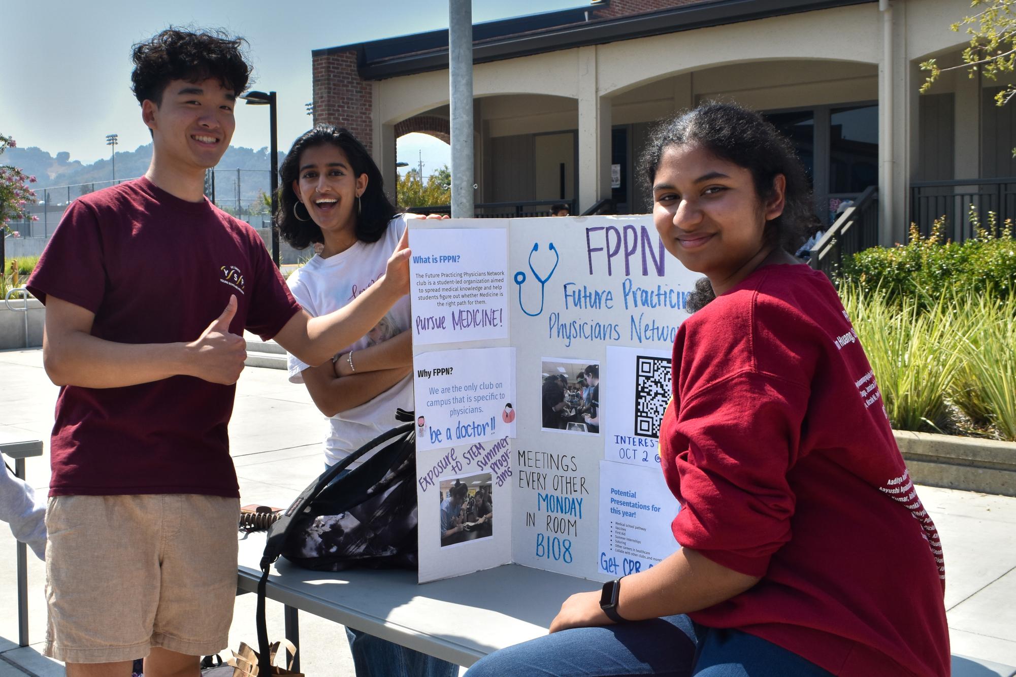 Members of the Future Practicing Physicians Network club show off their info board.