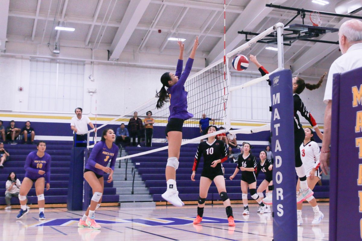 Sophomore Chloe Chen springs up to block a spike from GHS.