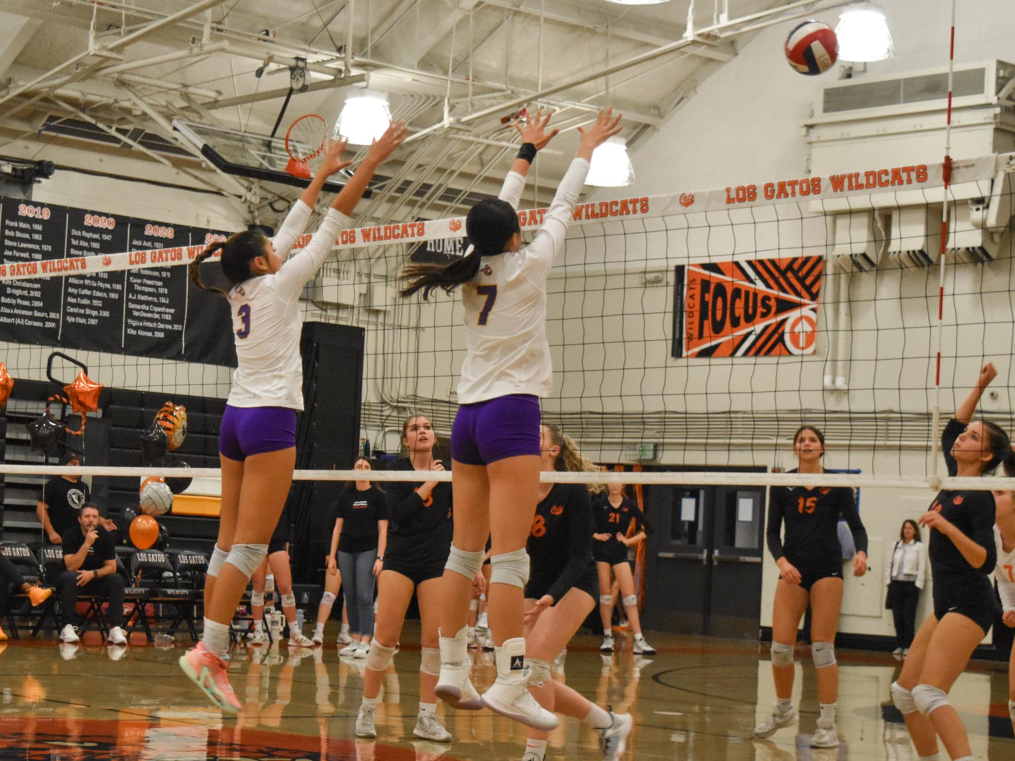 Junior Samantha Tong (left) and sophomore Chloe Chen (right) block an incoming spike from LGHS. 

