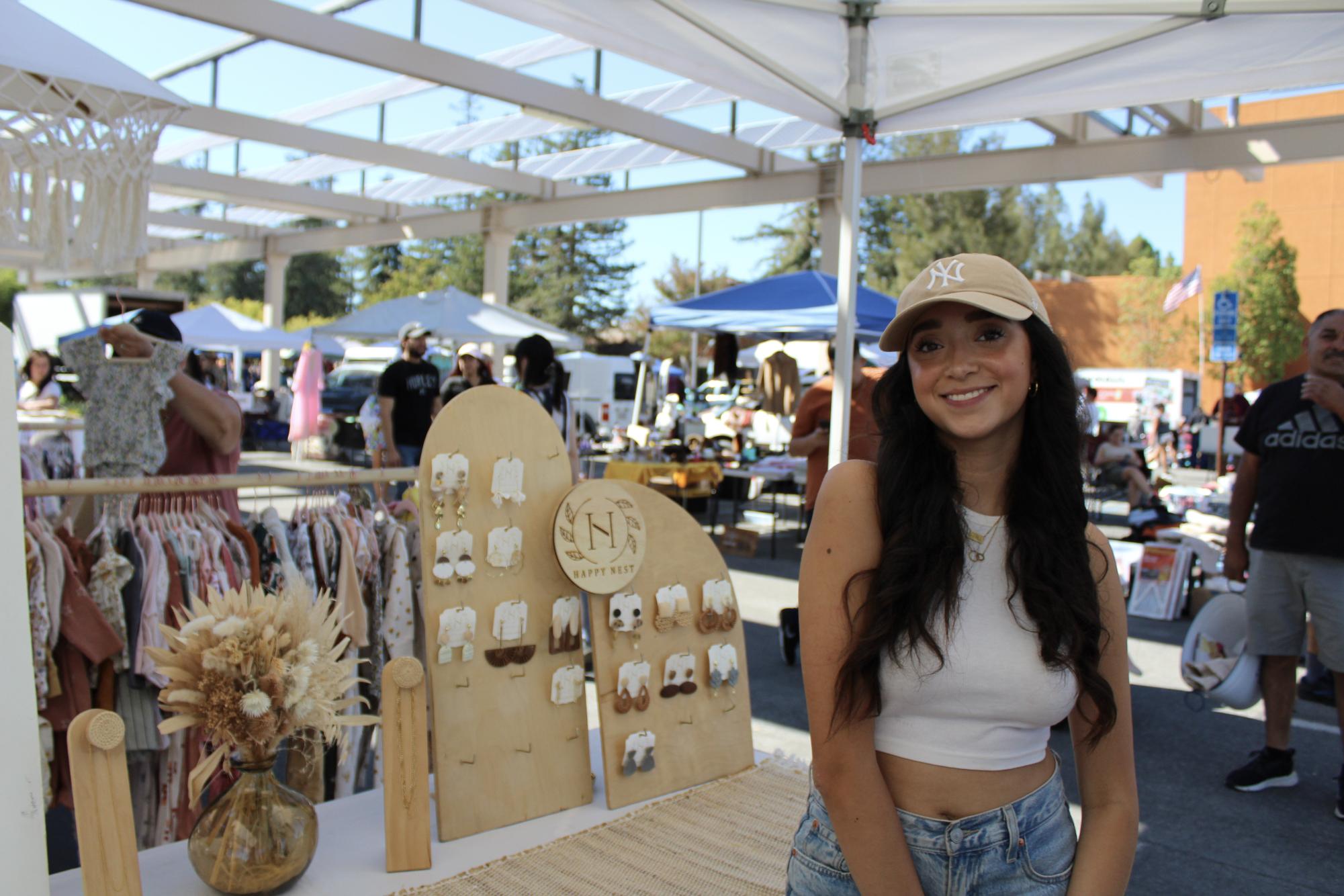 Irie Ramirez poses next to a stand of Happy Nest earrings.