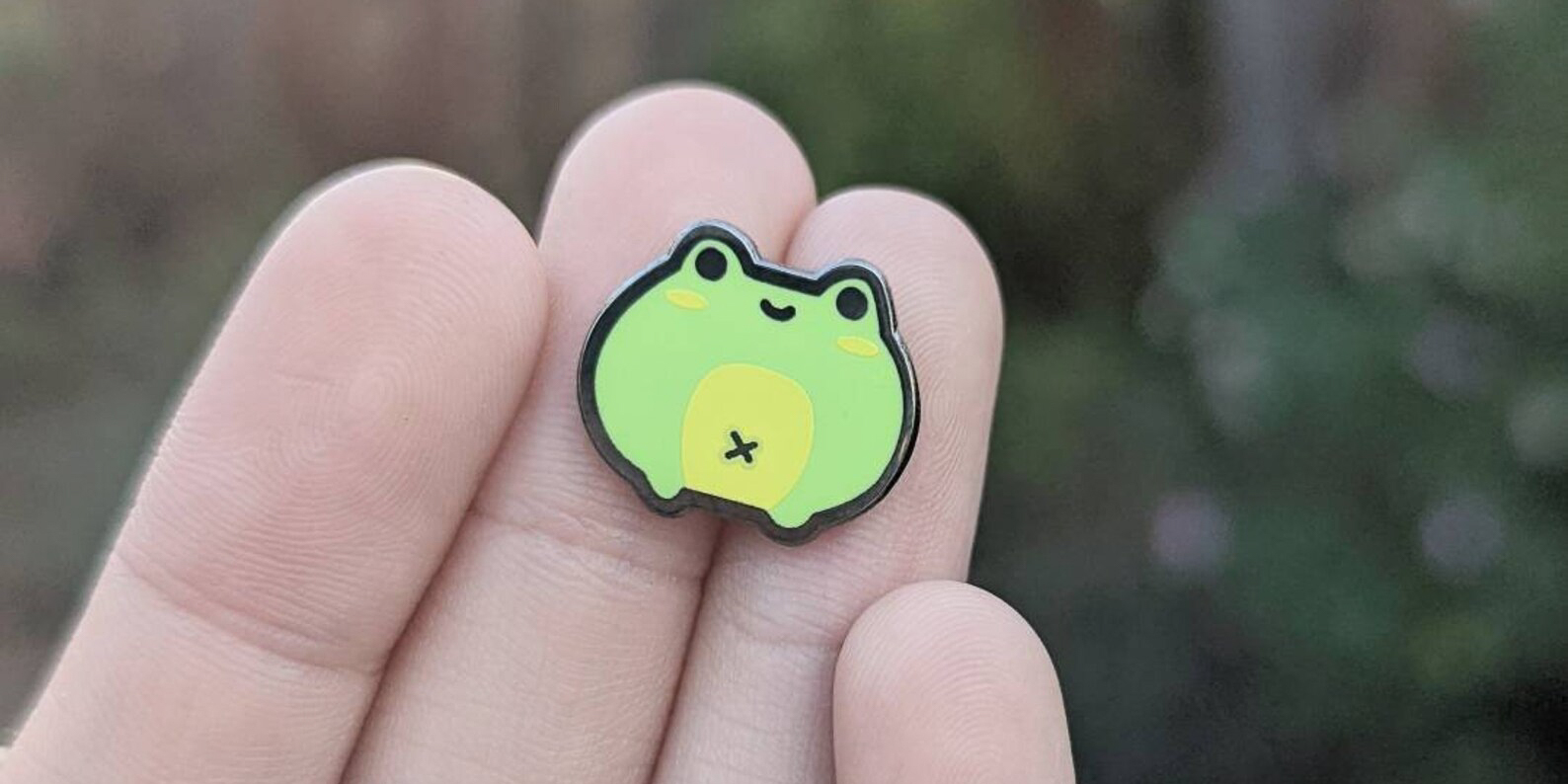 Frog enamel pin sold at Anqi Chens Etsy shop @Anqchii. Photo courtesy of Anqi Chen.