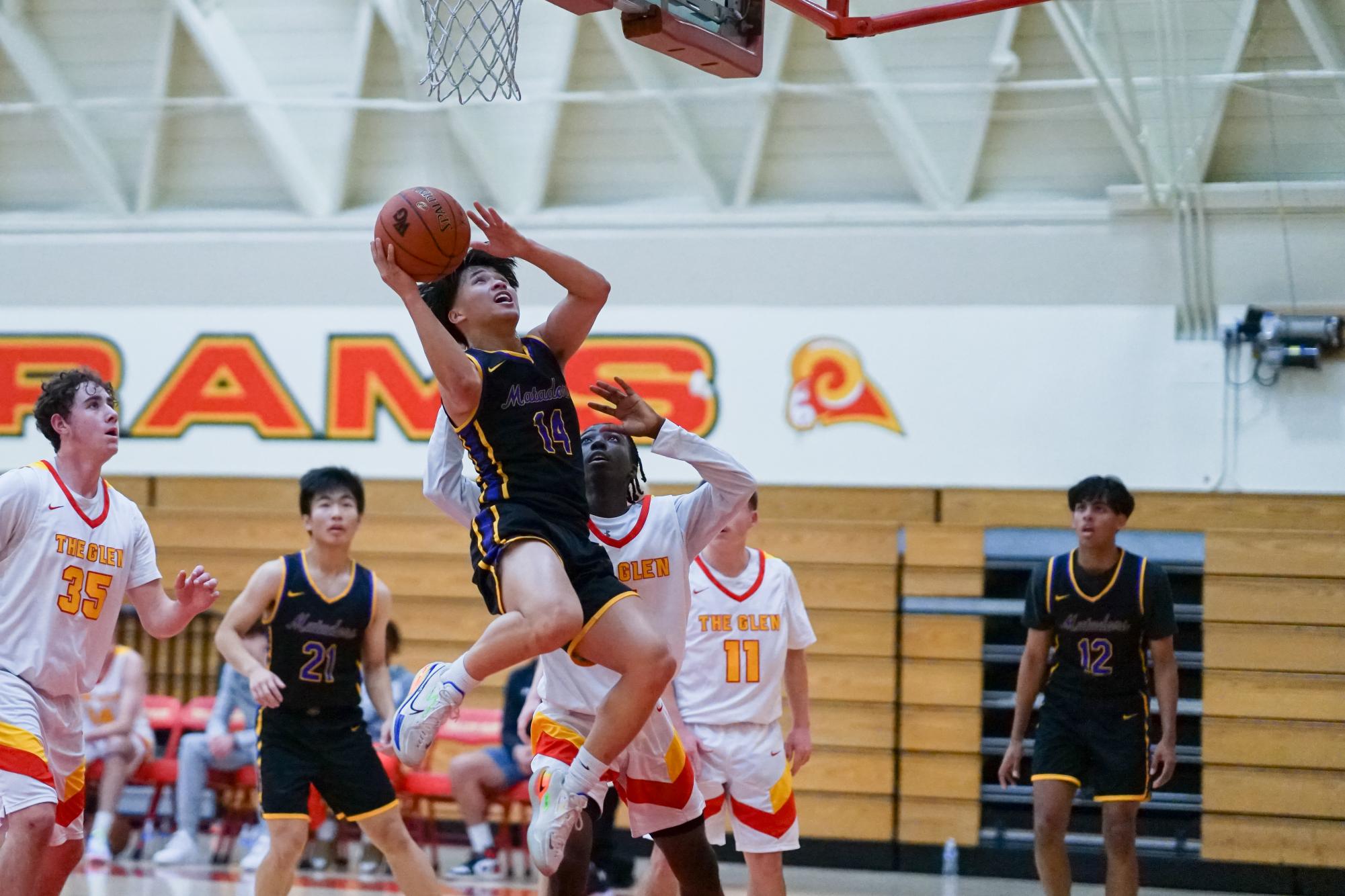 Senior and point guard Matthew Lau jumps to score the ball over a defender.

