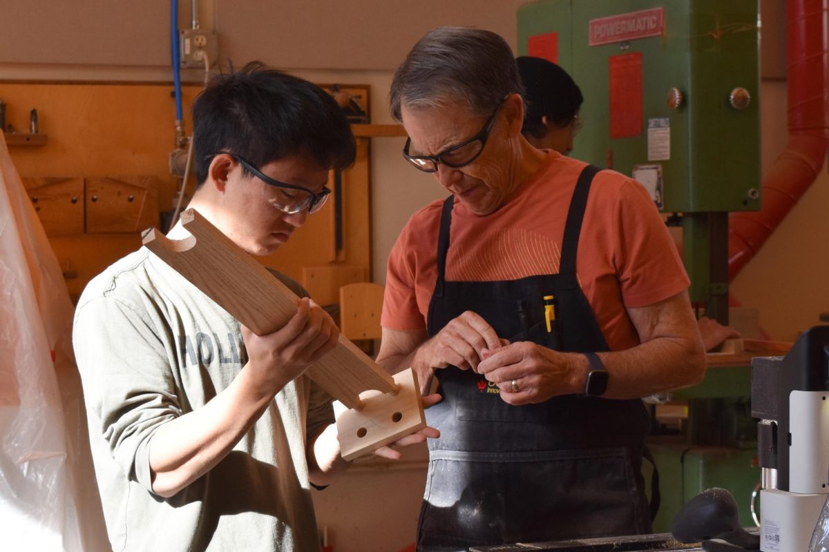 Assistant Phil Roybal helps junior Aaron Hung with his woodworking project.