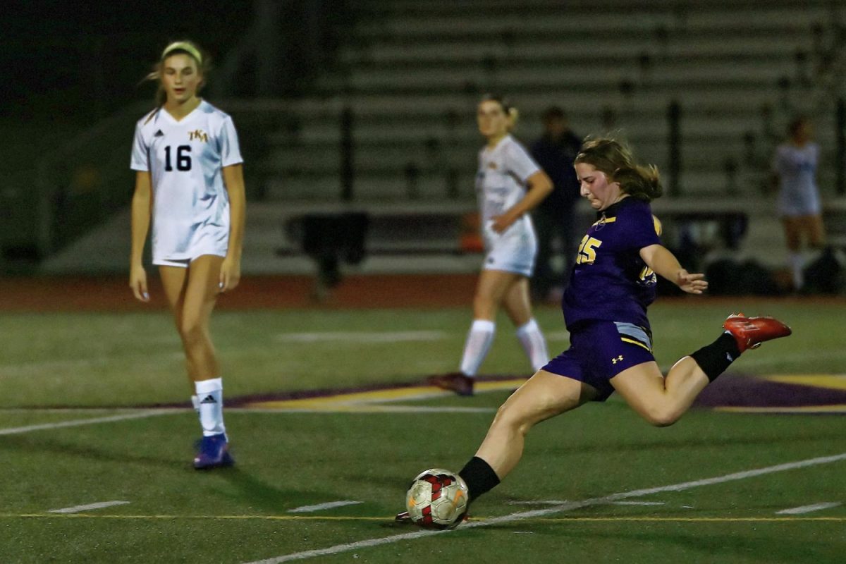 Junior and outside back Erin Handlesman arches her leg back to take a powerful shot at the soccer ball downfield.