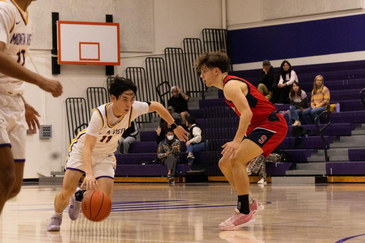 Senior and guard Jake Nakamura avoids opponents while dribbling the ball down the court.