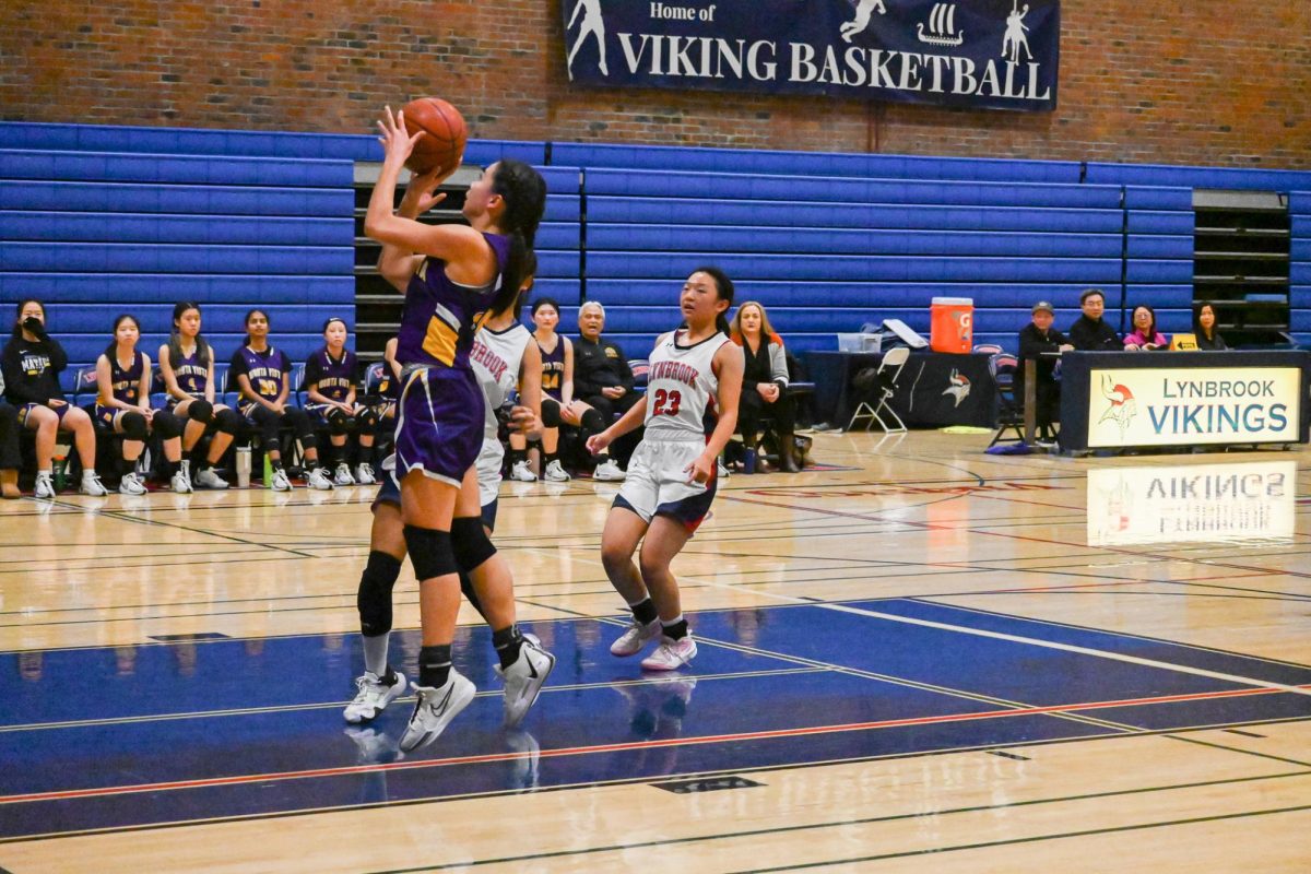 Junior and shooting guard Clara Fan attempts a fastbreak layup with two LHS opponents close behind her.