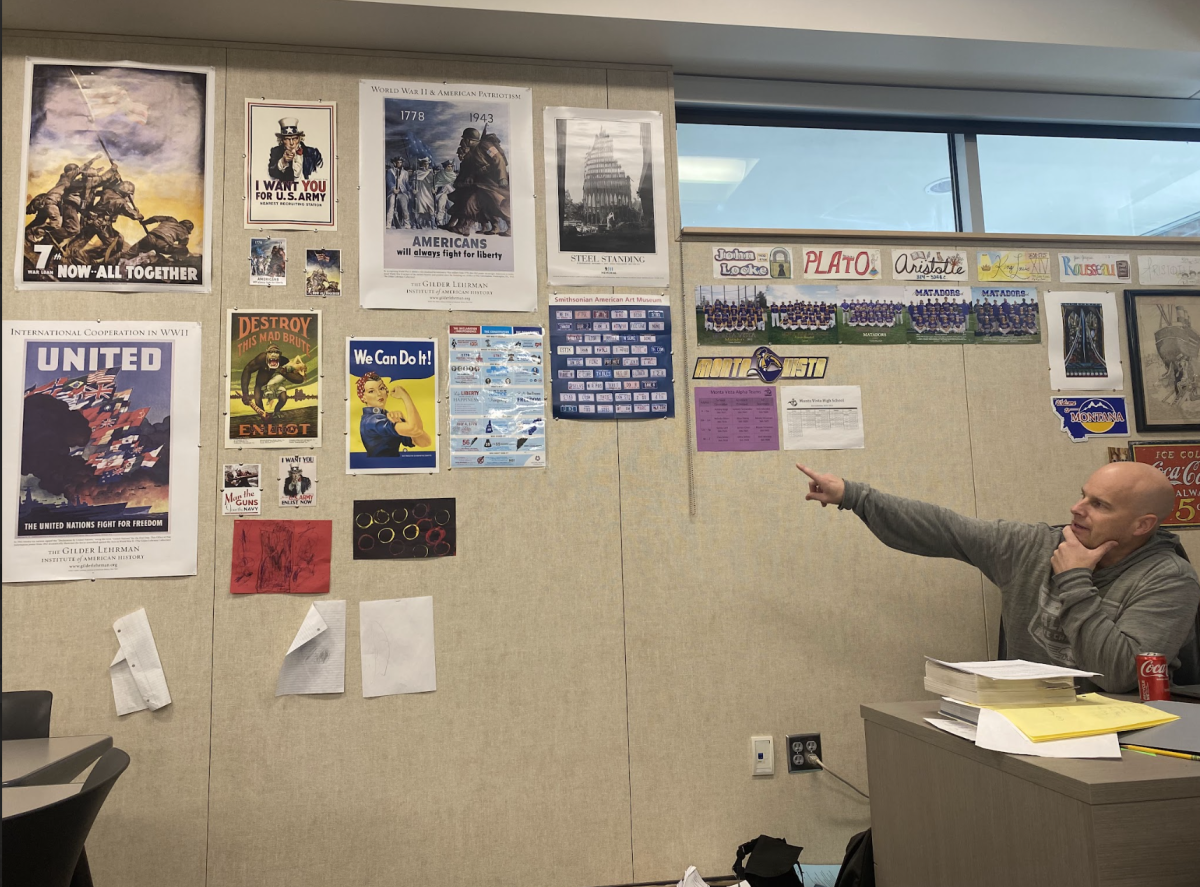 History teacher Robbie Hoffman points to the various posters on his classroom wall. 