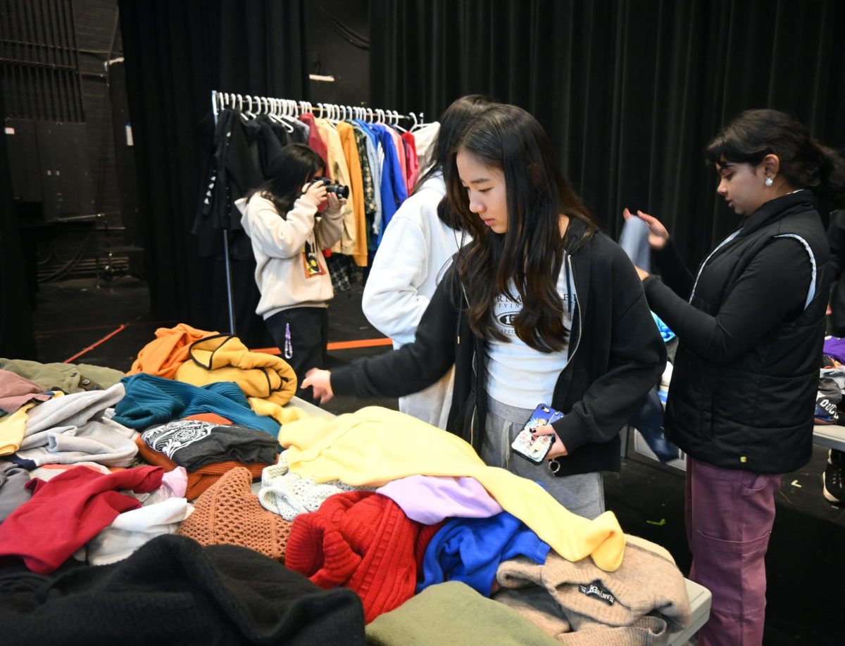 Freshman Celene Chen browses through clothes in the sweaters and jackets section. Photo courtesy of Sophia D’Sa, Jillian Ju and Shannon Yu