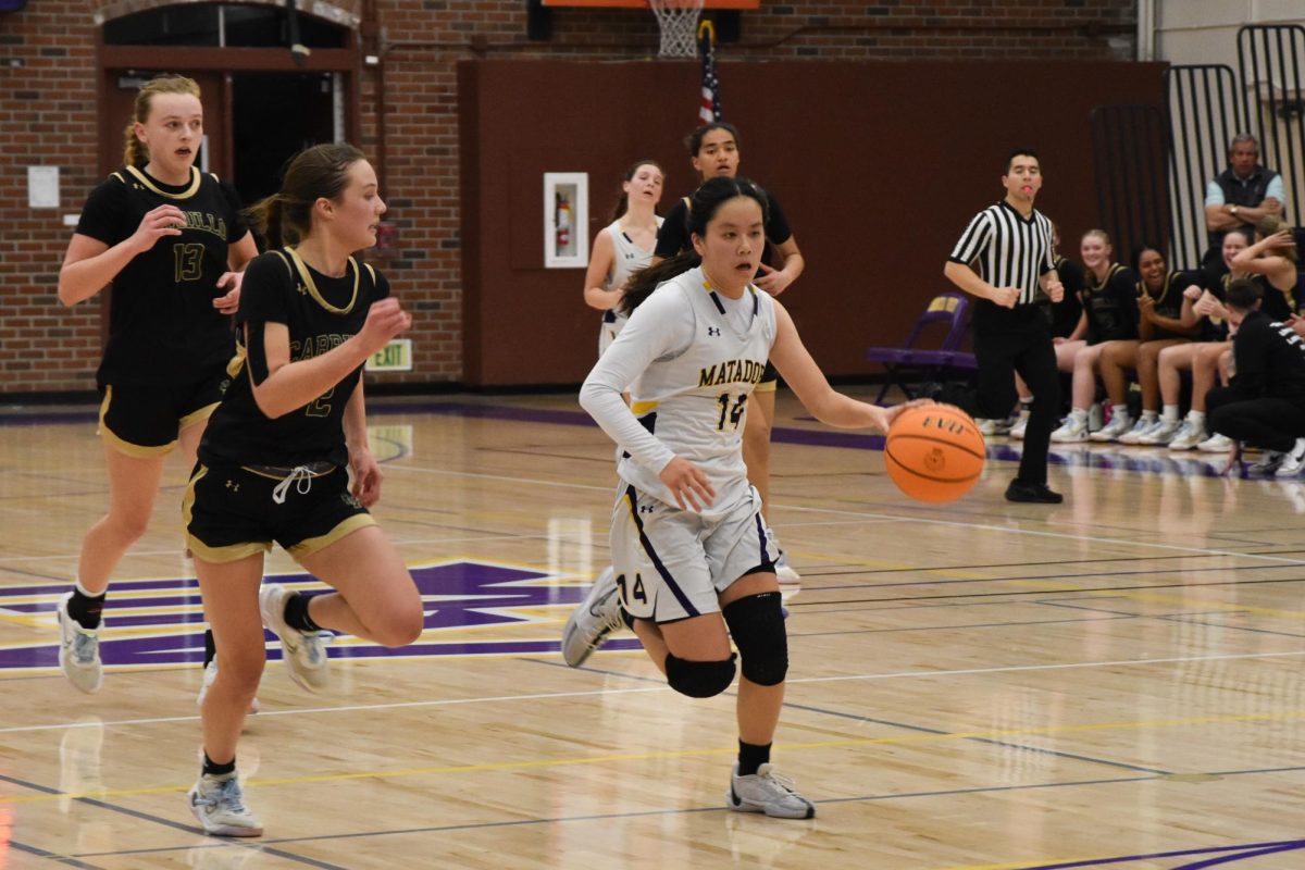 Senior and guard Vivian Ong drives the ball from the three-point line while evading a defender. 