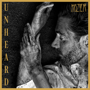 The Unheard album cover features a monochromatic photo of Hozier laying in dirt with a mustard yellow border. 
