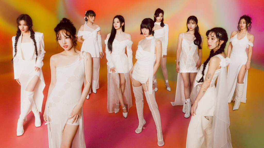 TWICE members pose in elaborate white outfits against a vivid fuschia and orange background.