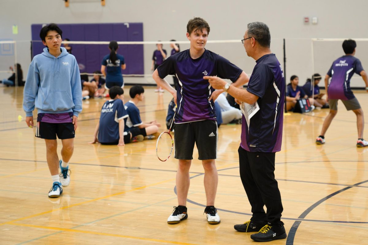 Badminton Head Coach Russell Okuno gives advice to sophomore Maxim Gutnik after his first set of Varsity 3 Boys Singles against Lynbrook High School.